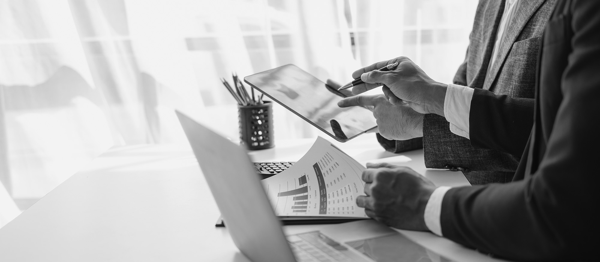 Consultant using a tablet during a consultation between bookkeepers and an accounting lawyer.